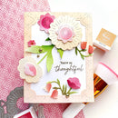 Handmade card with floral design and 'You're so thoughtful' text, surrounded by crafting tools on a pink patterned background.