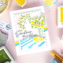 Card with lemon design and text 'Sending you a little sunshine' on a pink background with craft supplies.
