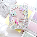 Card with butterfly and floral design surrounded by craft supplies on a white background