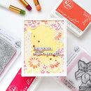 Card with floral design and text 'Just for you, with a smile' surrounded by rubber stamps and ink pads.