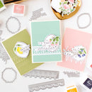 Card-making supplies including stamps, dies, and decorated cards on a white surface.