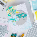 Card with floral design and 'Hugs & Happy Thoughts' text, surrounded by crafting tools on a light background.
