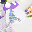 Handmade birthday card with blue floral design and 'Happy Birthday' text, surrounded by markers and a stamp set.