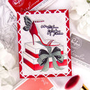 Card with high-heeled shoe design and 'one step at a time' text, surrounded by craft supplies.