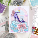 Colorful card with high heel shoe and decorative elements on a crafting table.