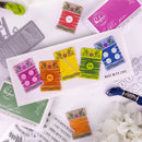 Colorful embroidered patches on a white surface with craft materials.