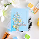 Card with floral design and text on a table with stamping supplies