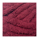Close-up of a textured burgundy fabric with a white background