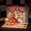 Pop-up card with clowns and a cat on a checkered floor with a theater backdrop