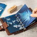 Blue notebook with floral design on a gray surface