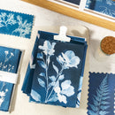 Set of blue floral prints on a white surface with a wooden frame.
