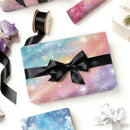 Gift box with galaxy-themed wrapping paper and black ribbon on a white background