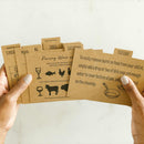 Hands holding brown paper cards with text and illustrations on a light background