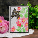 Card with 'Happy Spring' text and floral design, surrounded by pink flowers and greenery.