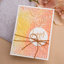 Decorative card with embossed design, string, and 'Happy' text on a beige background