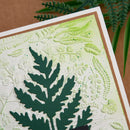 Card with embossed green leaf design on a textured surface