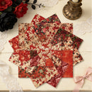 Stack of floral fabric squares on a wooden surface with decorative elements.