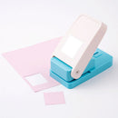 Blue and pink paper punch on a white background with pink paper pieces.