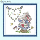 Cross-stitched design of a rabbit in a dress with flowers and butterflies on a light blue background.