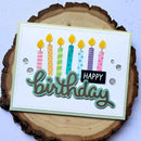 Birthday card with colorful candles and 'Happy Birthday' text on a wooden background
