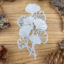 Metal leaf cutting die on a wooden surface with pine cones