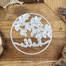 Decorative metal cutout with leaf design and 'alla' text on a wooden surface
