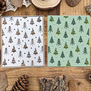 Two stencils with tree patterns on a wooden surface with natural elements.