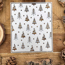 Metal stencil with Christmas tree pattern on a wooden surface