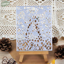 Decorative metal cutting die on a small easel with pinecones and a lace background