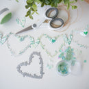 Crafting materials including scissors, sequins, and decorative elements on a white surface.