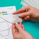 Hands holding a small white envelope with packaging materials in the background