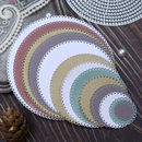 Set of round, scalloped-edge paper circles in pastel colors on a wooden surface.