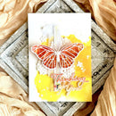 Greeting card with a butterfly design and 'Thinking of you' text on a textured surface.