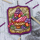 Colorful cake illustration on a decorative background with metal dies.