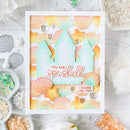 Card with beach-themed design featuring houses and seashells, surrounded by crafting supplies.