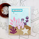 Card with ocean-themed design featuring pink and purple coral and a starfish, surrounded by crafting materials.