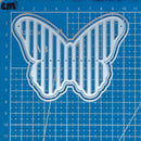 Metal butterfly-shaped cutting die on a blue grid background