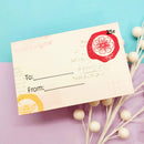 Vintage-style gift tag with floral design and 'To' and 'From' fields on a colorful background.