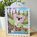 Greeting card with a koala design on a wooden surface with a plant in the background