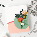 Handmade card with floral design and 'You are so kind' message, surrounded by crafting tools.