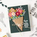 Handmade card with paper flowers and text 'here's a little paper hug' on a white background.