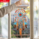 Decorative dreamcatcher with feathers hanging by a window