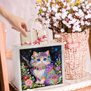 Decorative tote bag with a colorful cat design, held by a hand next to a basket of flowers.