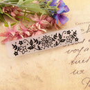 Decorative stamp with floral design on a textured paper background with flowers.