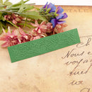 Green embossed bookmark on an old letter with flowers