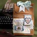 Decorative brown box with a white ribbon, vintage-style labels, and a blurred background.