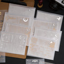 Set of clear stamp sheets with embossed designs on a dark surface