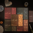 Collection of elegant stationery items with floral designs on a dark surface.