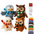 Four crocheted owl toys with scarves and a skein of yarn on a white background.