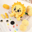 Yellow crochet sun character with yarn and tools on a white surface